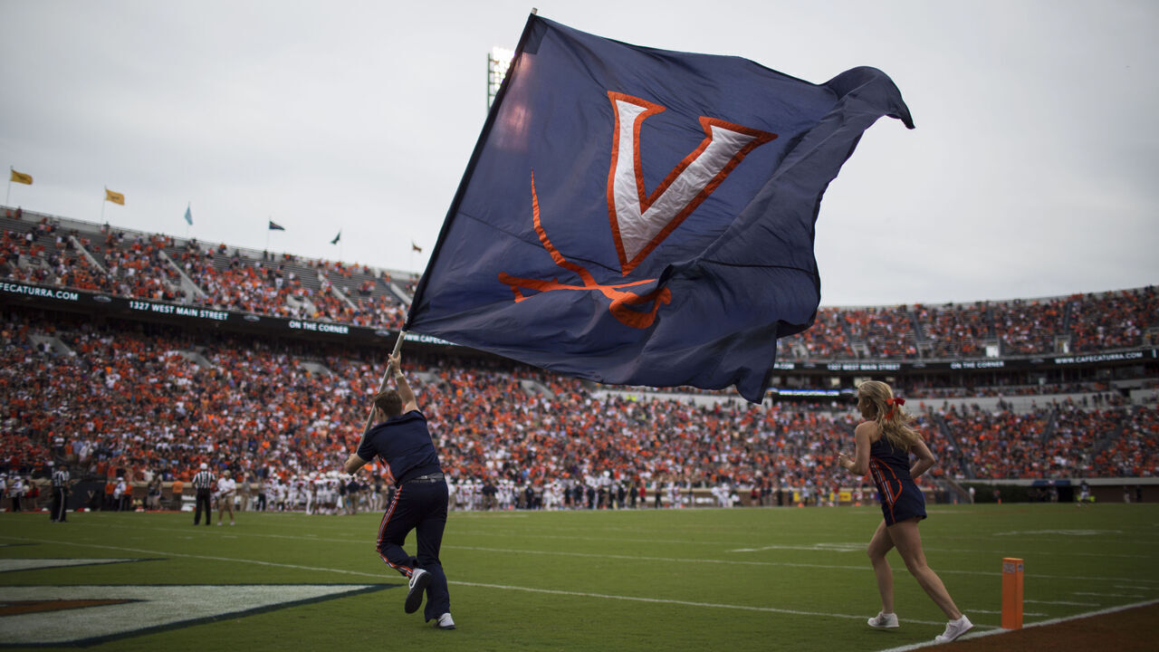 CHARLOTTESVILLE, VA - SEPTEMBER 03: Cheerleaders raise the Virginia Cavaliers flag after a UVA touchdown during a game against the Richmond Spiders at Scott Stadium on September 3, 2016 in Charlottesville, Virginia. Richmond beat Virginia 37-20 in the Virginia Cavaliers home opener.