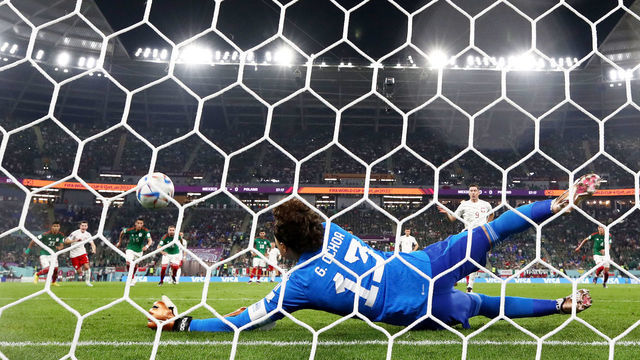 DOHA, QATAR - NOVEMBER 22: (EDITORS NOTE: In this photo taken from a remote camera from behind the goal) Robert Lewandowski of Poland shoots a penalty which is saved by Guillermo Ochoa of Mexico during the FIFA World Cup Qatar 2022 Group C match between Mexico and Poland at Stadium 974 on November 22, 2022 in Doha, Qatar.
