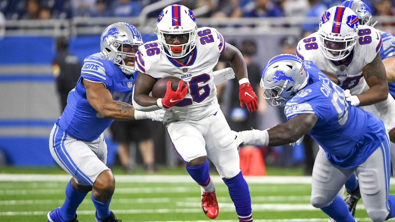 DETROIT, MICHIGAN - AUGUST 13: Devin Singletary #26 of the Buffalo Bills runs the ball against Romeo Okwara #95 of the Detroit Lions, left, and Jashon Cornell #96 of the Detroit Lions during the first quarter of the preseason game at Ford Field on August 13, 2021 in Detroit, Michigan.