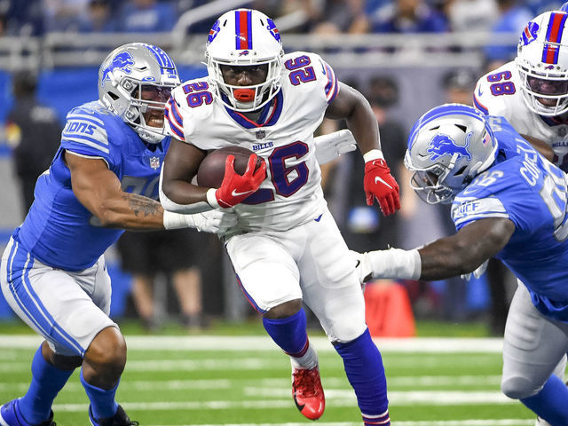 DETROIT, MICHIGAN - AUGUST 13: Devin Singletary #26 of the Buffalo Bills runs the ball against Romeo Okwara #95 of the Detroit Lions, left, and Jashon Cornell #96 of the Detroit Lions during the first quarter of the preseason game at Ford Field on August 13, 2021 in Detroit, Michigan.