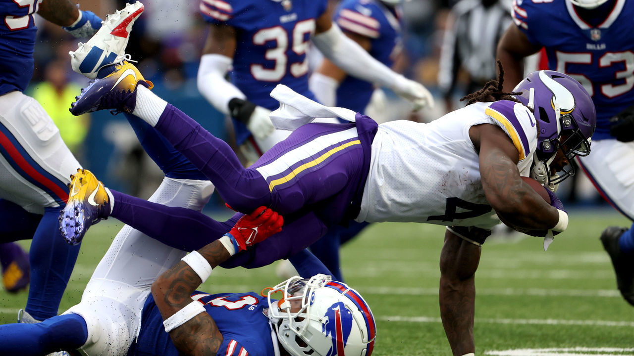 ORCHARD PARK, NEW YORK - NOVEMBER 13: Dalvin Cook #4 of the Minnesota Vikings flies over Damar Hamlin #3 of the Buffalo Bills during the third quarter at Highmark Stadium on November 13, 2022 in Orchard Park, New York.