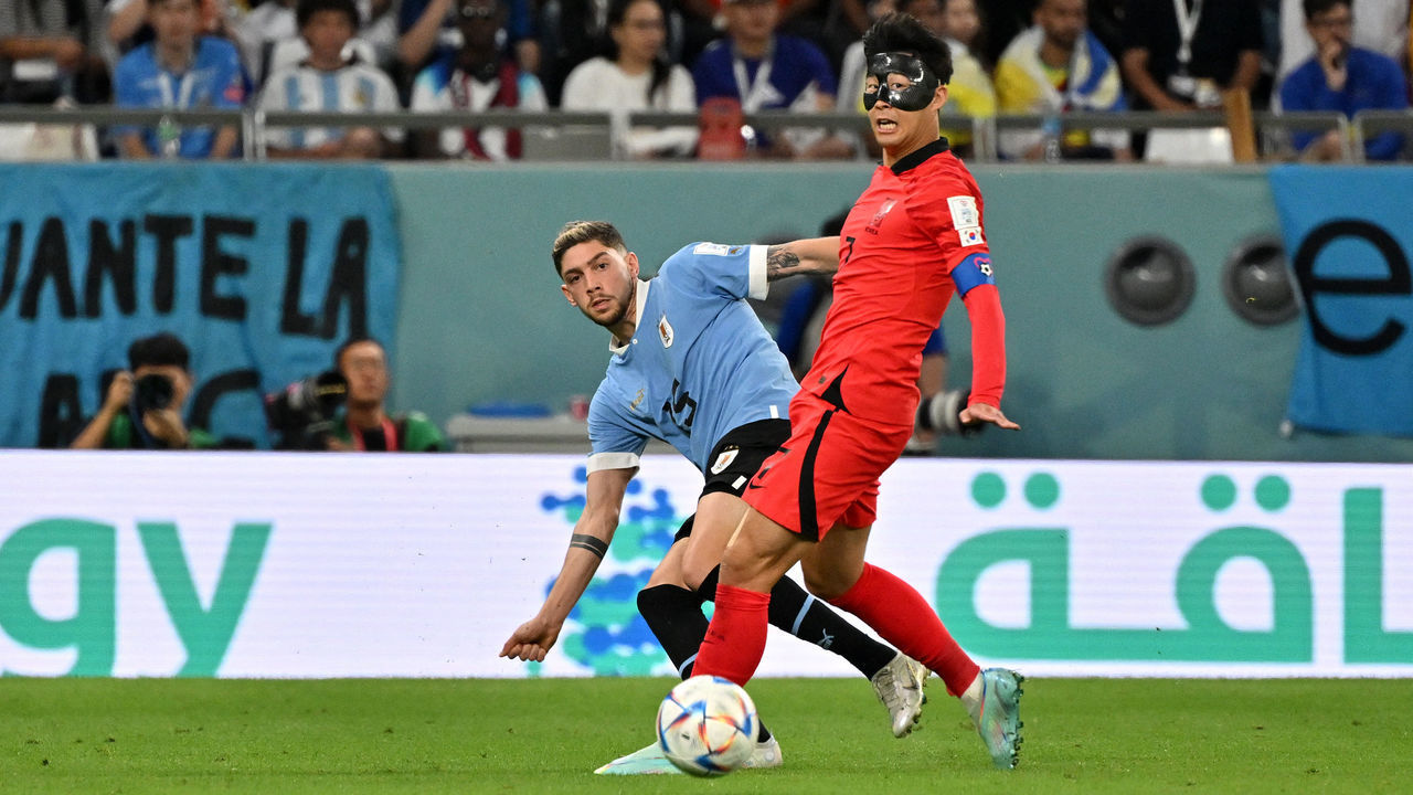 South Korea's midfielder #07 Son Heung-min runs with the ball past Uruguay's midfielder #15 Federico Valverde during the Qatar 2022 World Cup Group H football match between Uruguay and South Korea at the Education City Stadium in Al-Rayyan, west of Doha on November 24, 2022.