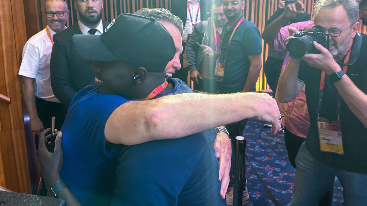 24 November 2022, Qatar, Doha: Louis van Gaal (hidden), national soccer coach of the Netherlands, hugs journalist Papa Gueye from Senegal after a press conference. Van Gaal hugged Guye after the press conference after the latter told him how much he admires him instead of asking a question. (to dpa ""Een big Knuffel": Van Gaal hugs journalist for praise") Photo: Thomas Bachmann/dpa
