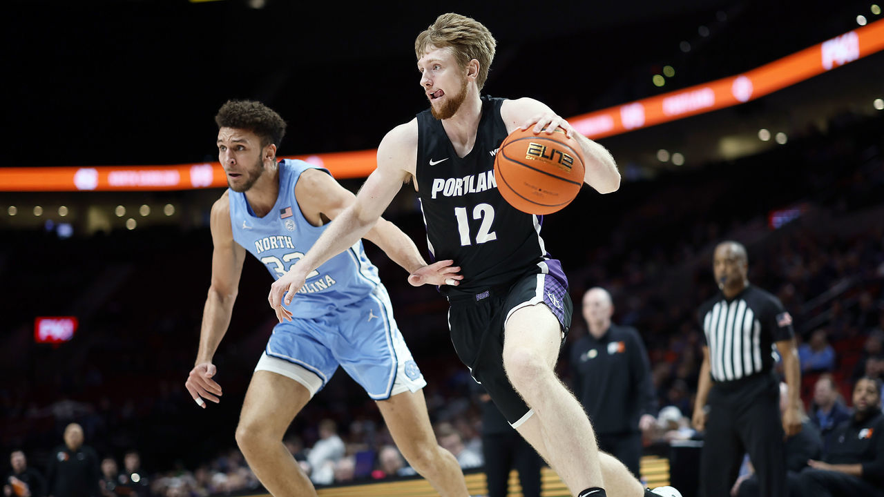 PORTLAND, OREGON - NOVEMBER 24: Kristian Sjolund #12 of the Portland Pilots dribbles the ball past Pete Nance #32 of the North Carolina Tar Heels during the first half at Moda Center on November 24, 2022 in Portland, Oregon.