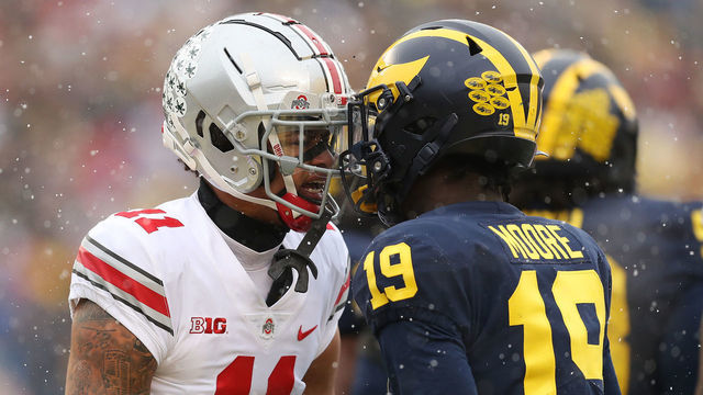 ANN ARBOR, MICHIGAN - NOVEMBER 27: Jaxon Smith-Njigba #11 of the Ohio State Buckeyes and Rod Moore #19 of the Michigan Wolverines talk during the first quarter at Michigan Stadium on November 27, 2021 in Ann Arbor, Michigan.
