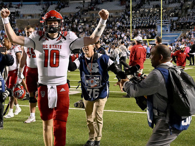 CHAPEL HILL, NORTH CAROLINA - NOVEMBER 25: Ben Finley #10 of the North Carolina State Wolfpack celebrates after a win against the North Carolina Tar Heels at Kenan Memorial Stadium on November 25, 2022 in Chapel Hill, North Carolina. The Wolfpack won 30-27 in overtime.