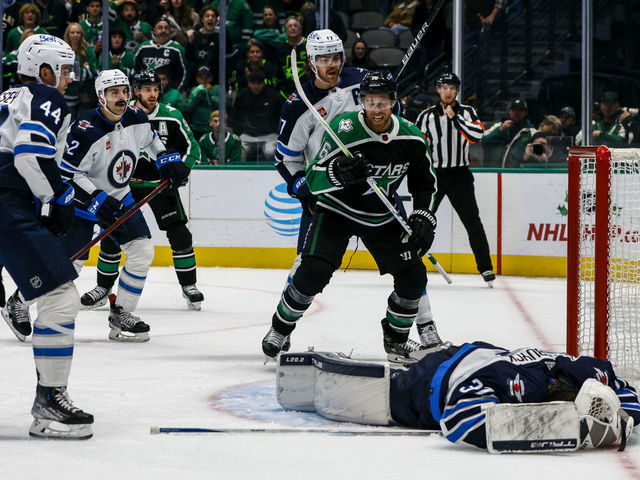 DALLAS, TX - NOVEMBER 25: Dallas Stars center Joe Pavelski (16) celebrates a goal as Winnipeg Jets goaltender Connor Hellebuyck (37) lays on the ice during the game between the Dallas Stars and the Winnipeg Jets on November 25, 2022 at American Airlines Center in Dallas, Texas.