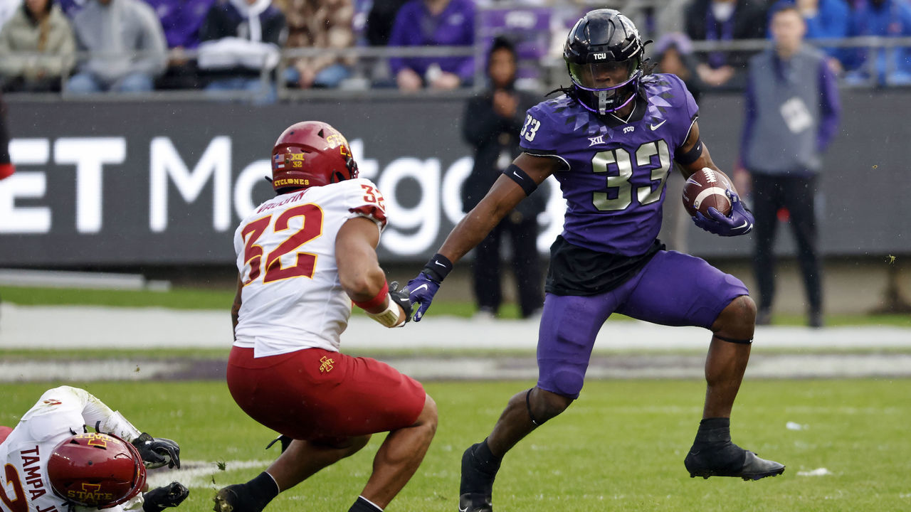 FORT WORTH, TX - NOVEMBER 26: Running back Kendre Miller #33 of the TCU Horned Frogs carries the ball as linebacker Gerry Vaughn #32 of the Iowa State Cyclones closes during the first half at Amon G. Carter Stadium on November 26, 2022 in Fort Worth, Texas.
