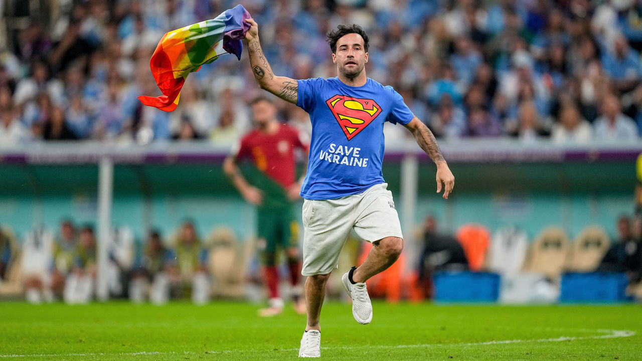 LUSAIL CITY, QATAR - NOVEMBER 28: A protester with Safe Ukraine lettering and rainbow flag on the pitch during the FIFA World Cup Qatar 2022 Group H match between Portugal and Uruguay at Lusail Stadium on November 28, 2022 in Lusail City, Qatar.