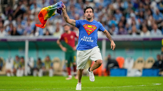 LUSAIL CITY, QATAR - NOVEMBER 28: A protester with Safe Ukraine lettering and rainbow flag on the pitch during the FIFA World Cup Qatar 2022 Group H match between Portugal and Uruguay at Lusail Stadium on November 28, 2022 in Lusail City, Qatar.