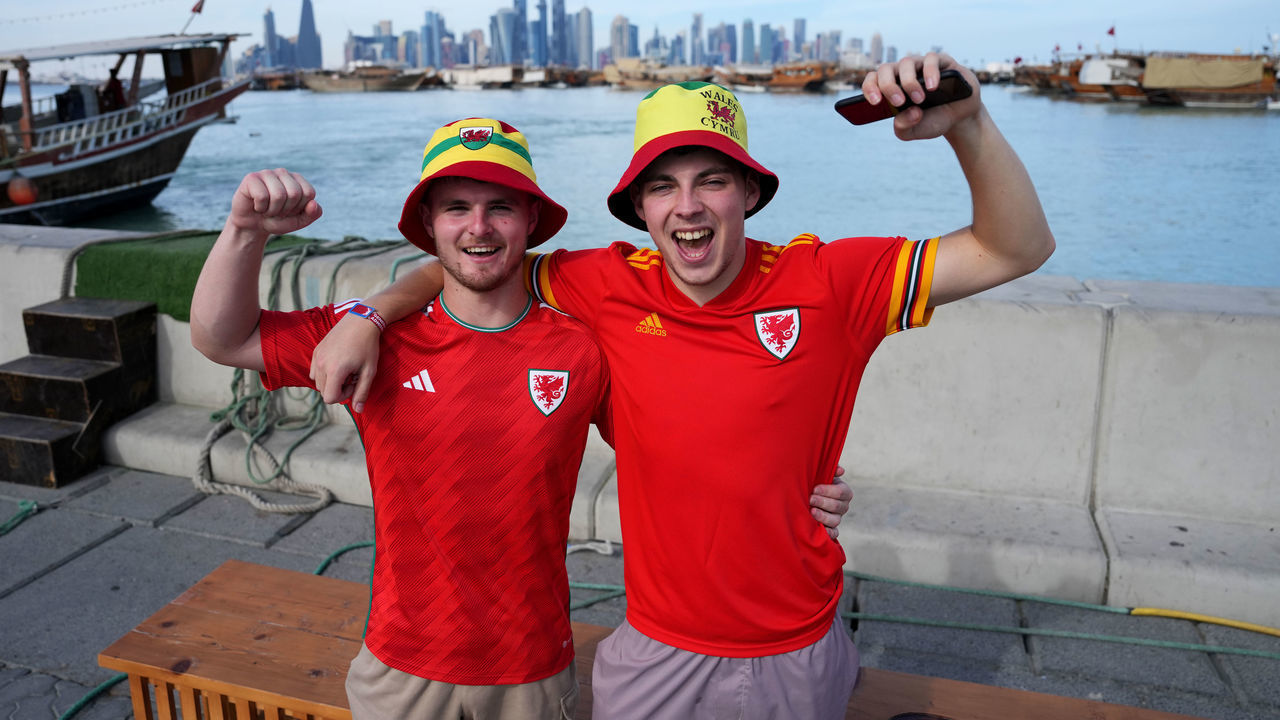 Wales fans pose for a photograph on the Corniche iin Doha on the day of the FIFA World Cup Group B match between Wales and England. Picture date: Tuesday November 29, 2022.