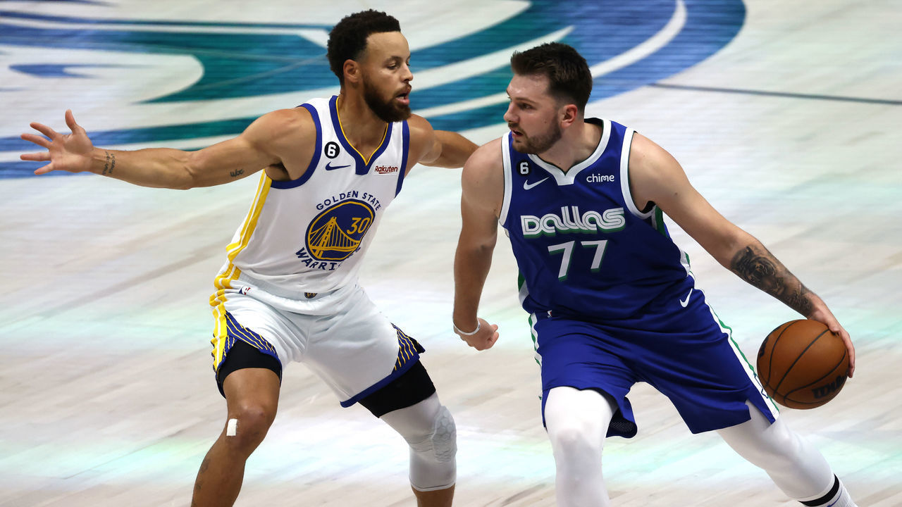 DALLAS, TX - NOVEMBER 29: Luka Doncic #77 of the Dallas Mavericks handles the ball as Stephen Curry #30 of the Golden State Warriors defends in the first half at American Airlines Center on November 29, 2022 in Dallas, Texas.