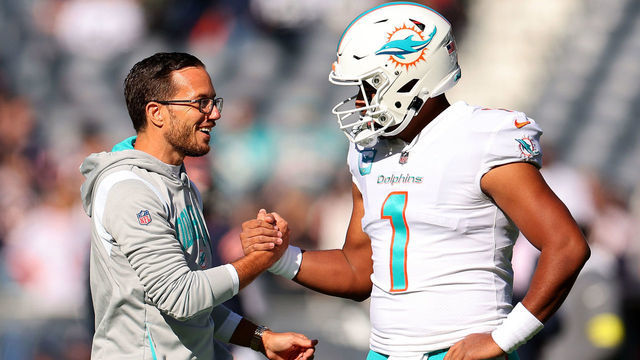 CHICAGO, ILLINOIS - NOVEMBER 06: Head coach Mike McDaniel of the Miami Dolphins speaks with Tua Tagovailoa #1 prior to the game against the Chicago Bears at Soldier Field on November 06, 2022 in Chicago, Illinois.