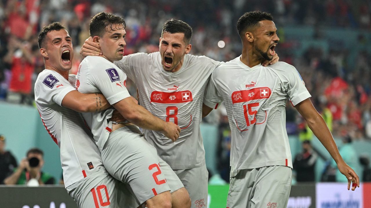 Switzerland's midfielder #23 Xherdan Shaqiri (2L) celebrates with teammates after scoring his team's first goal during the Qatar 2022 World Cup Group G football match between Serbia and Switzerland at Stadium 974 in Doha on December 2, 2022.