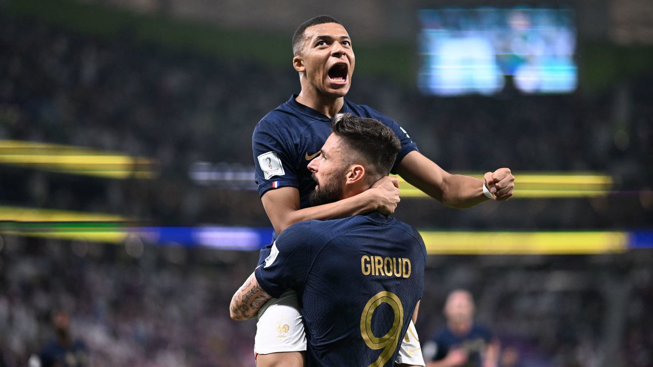 TOPSHOT - France's forward #09 Olivier Giroud celebrates with France's forward #10 Kylian Mbappe (top) after scoring his team's first goal during the Qatar 2022 World Cup round of 16 football match between France and Poland at the Al-Thumama Stadium in Doha on December 4, 2022.
