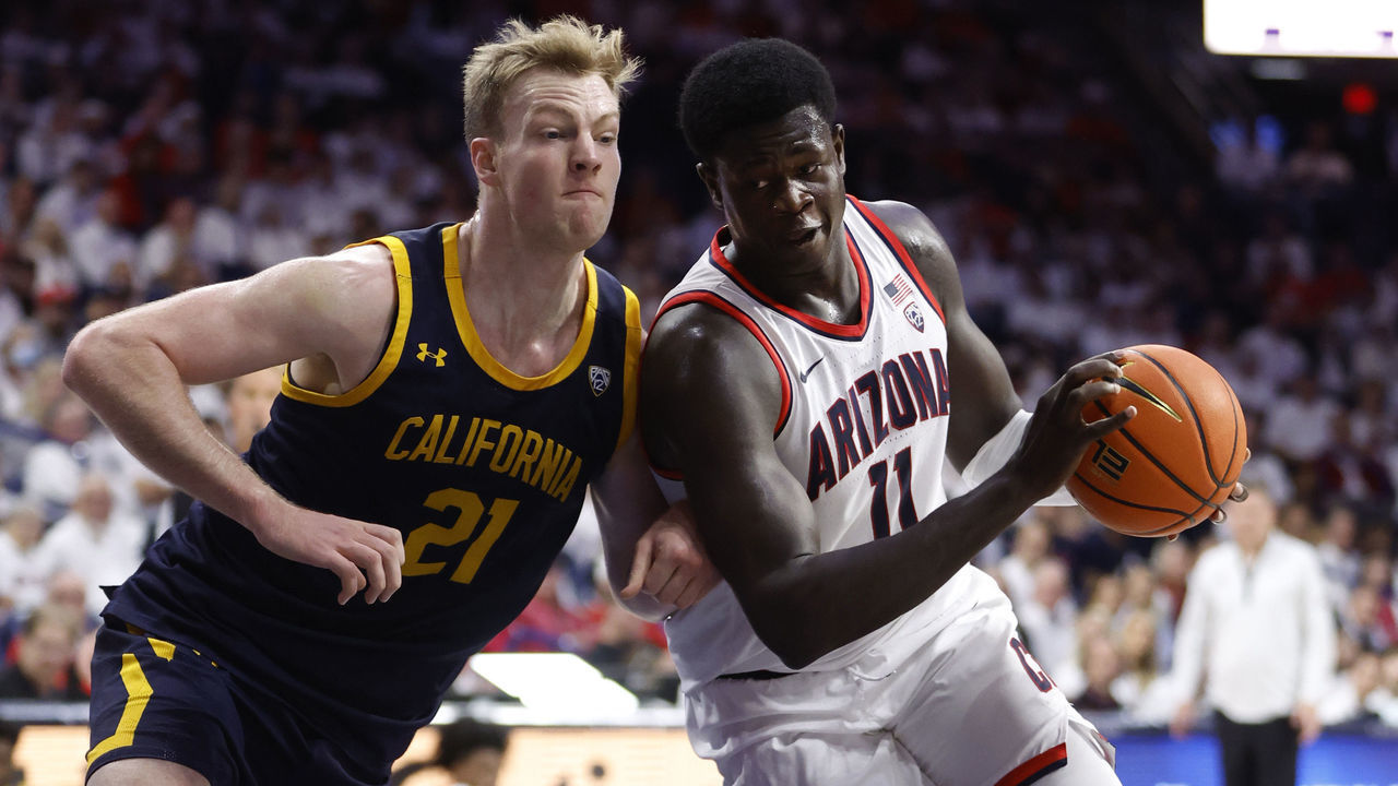 TUCSON, ARIZONA - DECEMBER 04: Oumar Ballo #11 of the Arizona Wildcats drives on Lars Thiemann #21 of the California Golden Bears during the first half at McKale Center on December 04, 2022 in Tucson, Arizona.