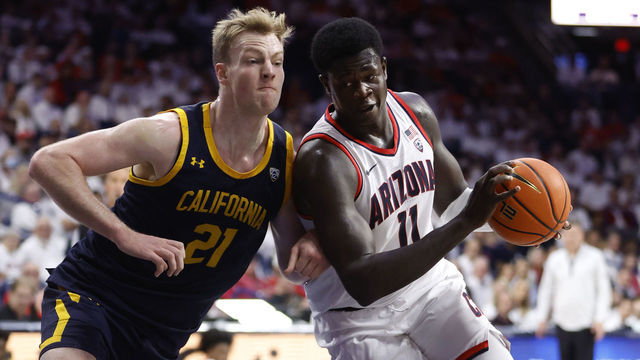 TUCSON, ARIZONA - DECEMBER 04: Oumar Ballo #11 of the Arizona Wildcats drives on Lars Thiemann #21 of the California Golden Bears during the first half at McKale Center on December 04, 2022 in Tucson, Arizona.