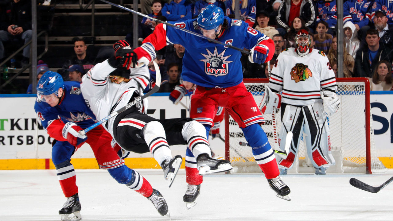 NEW YORK, NEW YORK - DECEMBER 03: Jacob Trouba #8 of the New York Rangers throws a hit against Andreas Athanasiou #89 of the Chicago Blackhawks at Madison Square Garden on December 3, 2022 in New York City.