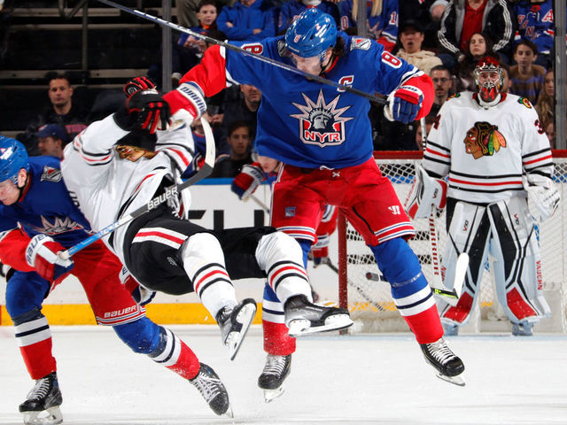 NEW YORK, NEW YORK - DECEMBER 03: Jacob Trouba #8 of the New York Rangers throws a hit against Andreas Athanasiou #89 of the Chicago Blackhawks at Madison Square Garden on December 3, 2022 in New York City.