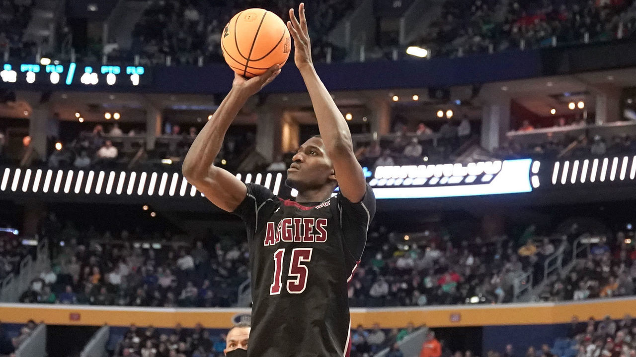 BUFFALO, NEW YORK - MARCH 17: Mike Peake #15 of the New Mexico State Aggies takes a jump shot over Tyrese Martin #4 of the Connecticut Huskies during the first round game of the 2022 NCAA Men's Basketball Tournament at KeyBank Center on March 17, 2022 in Buffalo, New York.