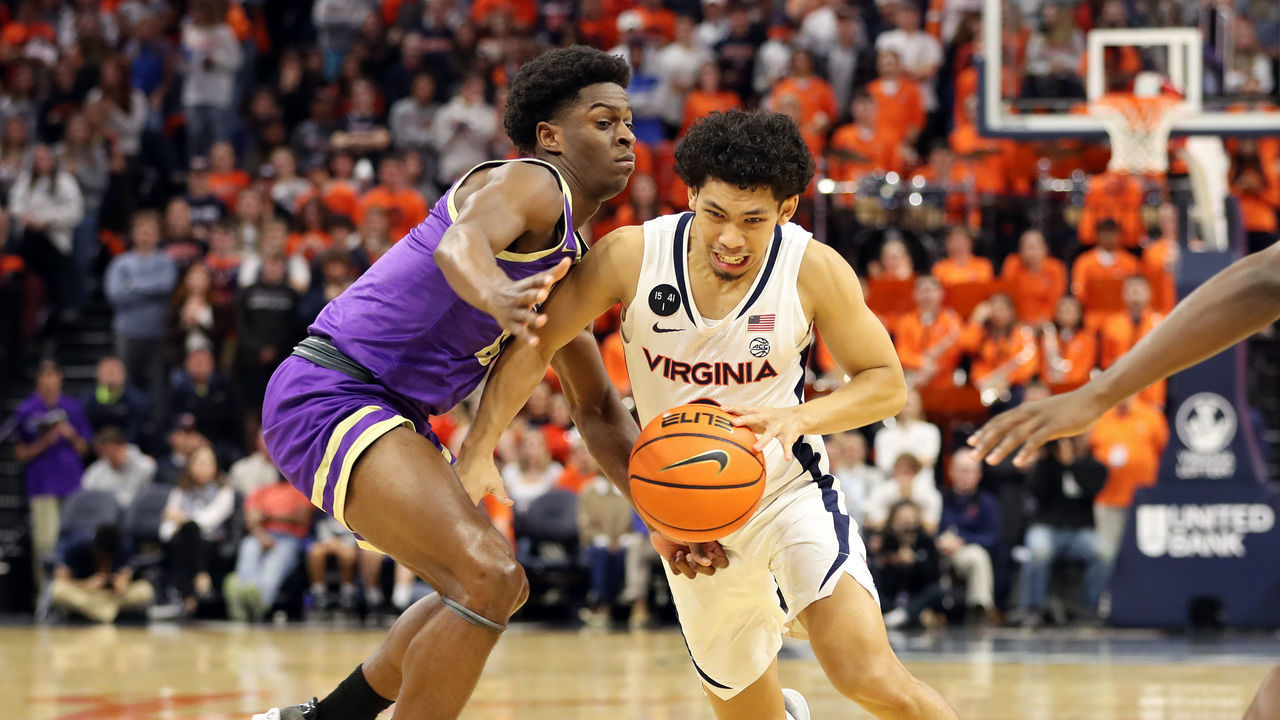 CHARLOTTESVILLE, VA - DECEMBER 06: Kihei Clark #0 of the Virginia Cavaliers drives past Xavier Brown #0 of the James Madison Dukes in the second half during a game at John Paul Jones Arena on December 6, 2022 in Charlottesville, Virginia.