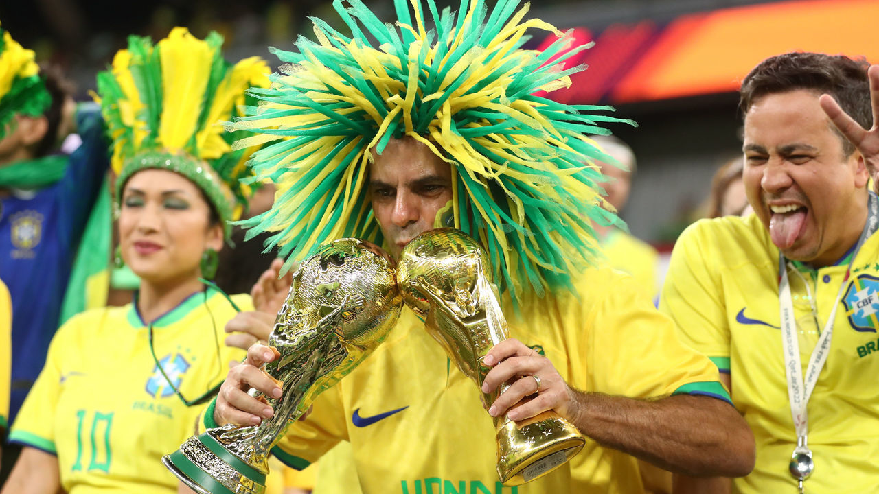 DOHA, QATAR - DECEMBER 05: A fan of Brazil kissing two replica World Cup trophies before the FIFA World Cup Qatar 2022 Round of 16 match between Brazil and South Korea at Stadium 974 on December 5, 2022 in Doha, Qatar.