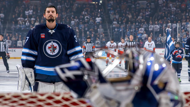 WINNIPEG, CANADA - DECEMBER 4: Goaltender Connor Hellebuyck #37 of the Winnipeg Jets looks on during the singing of the National anthems prior to puck drop against the Anaheim Ducks at the Canada Life Centre on December 4, 2022 in Winnipeg, Manitoba, Canada.
