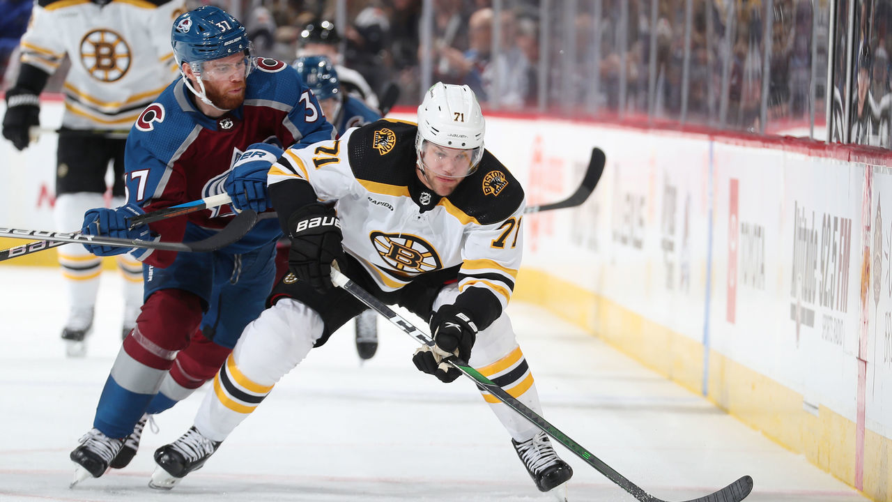 DENVER, COLORADO - DECEMBER 07: J.T. Compher #37 of the Colorado Avalanche skates against Taylor Hall #71 of the Boston Bruins at Ball Arena on December 7, 2022 in Denver, Colorado.