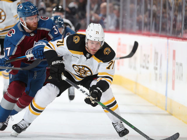 DENVER, COLORADO - DECEMBER 07: J.T. Compher #37 of the Colorado Avalanche skates against Taylor Hall #71 of the Boston Bruins at Ball Arena on December 7, 2022 in Denver, Colorado.