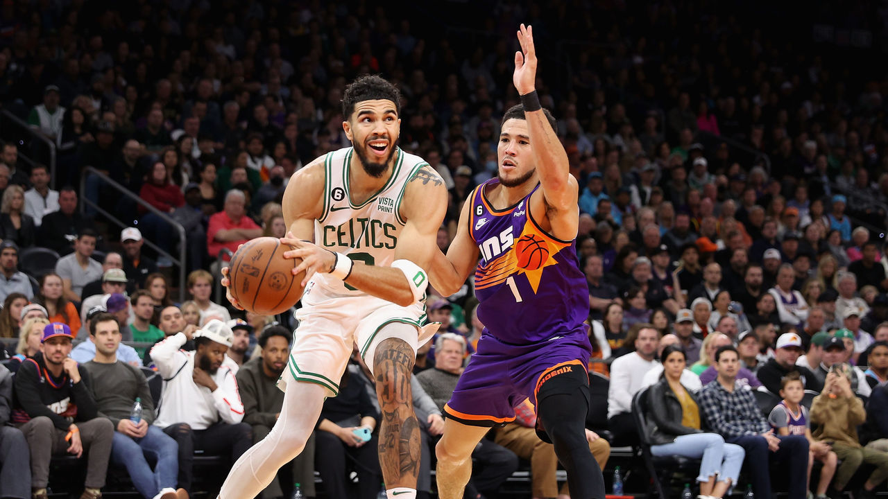 PHOENIX, ARIZONA - DECEMBER 07: Jayson Tatum #0 of the Boston Celtics drives the ball past Devin Booker #1 of the Phoenix Suns during the first half of the NBA game at Footprint Center on December 07, 2022 in Phoenix, Arizona.