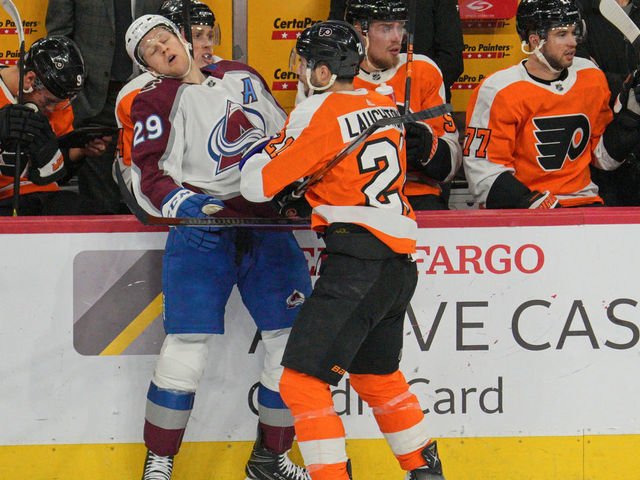 PHILADELPHIA, PA - DECEMBER 05: Colorado Avalanche center Nathan MacKinnon (29) is body checked by Philadelphia Flyers center Scott Laughton (21) during the game between the Colorado Avalanche and the Philadelphia Flyers on December 5, 2022 at the Wells Fargo Center in Philadelphia, PA