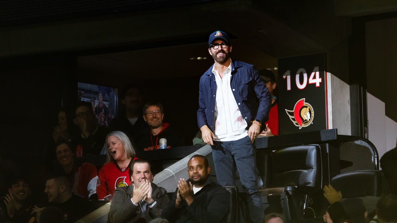 OTTAWA, ON - NOVEMBER 08: Canadian actor Ryan Reynolds stands in the spotlight while being announced during first period National Hockey League action between the Vancouver Canucks and Ottawa Senators on November 8, 2022, at Canadian Tire Centre in Ottawa, ON, Canada.