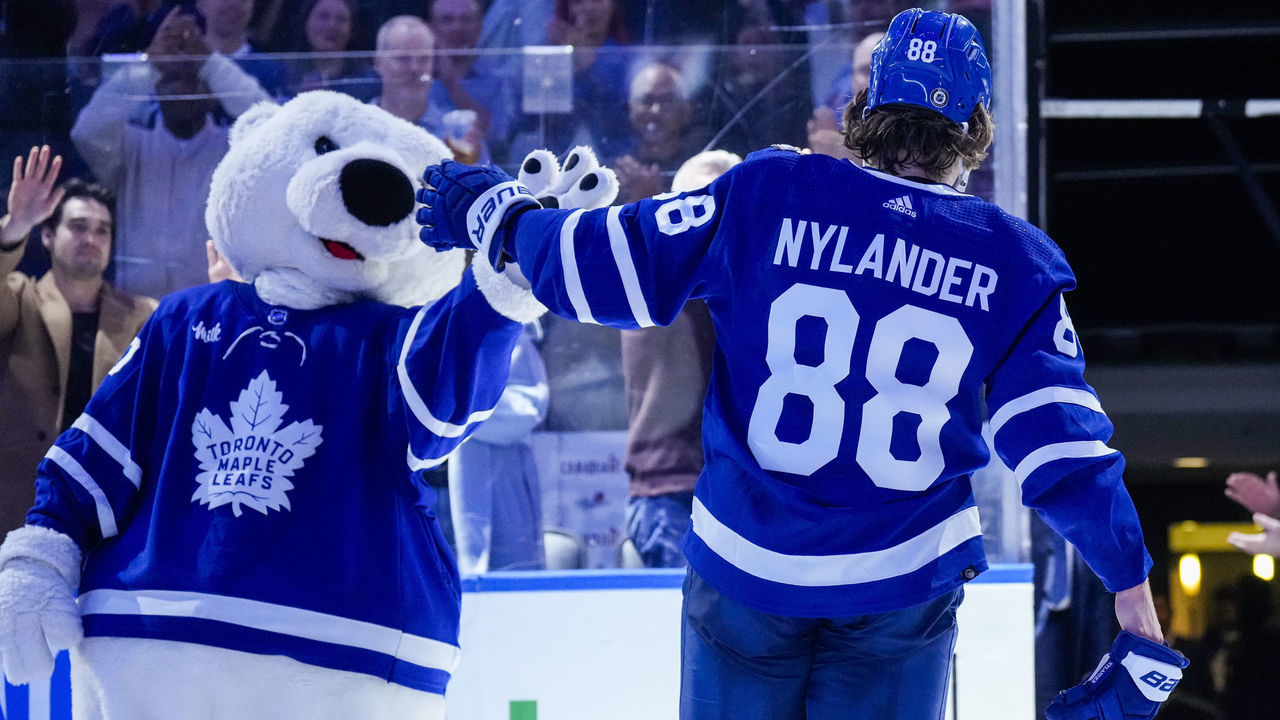 TORONTO, ON - DECEMBER 10: William Nylander #88 of the Toronto Maple Leafs high fives mascot Carlton the Bear after receiving a star of the game after defeating the Calgary Flames at the Scotiabank Arena on December 10, 2022 in Toronto, Ontario, Canada.