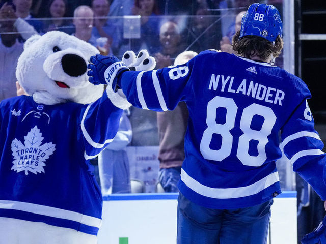 TORONTO, ON - DECEMBER 10: William Nylander #88 of the Toronto Maple Leafs high fives mascot Carlton the Bear after receiving a star of the game after defeating the Calgary Flames at the Scotiabank Arena on December 10, 2022 in Toronto, Ontario, Canada.