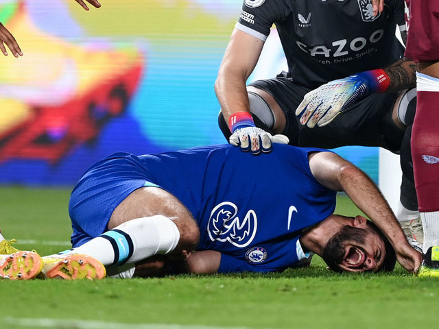 ABU DHABI, UNITED ARAB EMIRATES - DECEMBER 11: Armando Broja of Chelsea holds their leg, as teammates and players of Aston Villa offer support, during the Al Wahda Challenge Cup match between Chelsea and Aston Villa at Al Nahyan Stadium on December 11, 2022 in Abu Dhabi, United Arab Emirates.