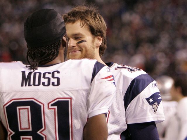EAST RUTHERFORD, NJ - DECEMBER 29: Tom Brady #12 of the New England Patriots and Randy Moss #81 look on from the bench against the New York Giants during their game on December 29, 2007 at Giants Stadium in East Rutherford, New Jersey. The Patriots defeated the Giants 38-35 to complete a perfect 16-0 regular season.