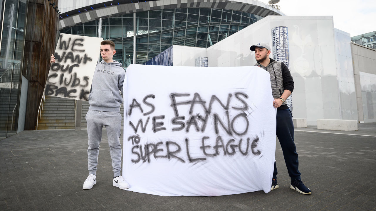 LONDON, UNITED KINGDOM - APRIL 20: Manchester United fan Jack Newson (L) and Tottenham Hotspur fan Cameron Bull hold their handmade signs as they protest against the proposed Super League outside the Tottenham Hotspur stadium on April 20, 2021 in London, United Kingdom. Six English premier league teams have announced they are part of plans for a breakaway European Super League. Arsenal, Manchester United, Manchester City, Liverpool, Chelsea and Tottenham Hotspur will join 12 other European teams in a closed league similar to that of the NFL American Football League. In a statement released last night, the new competition "is intended to commence as soon as practicable" potentially in August.