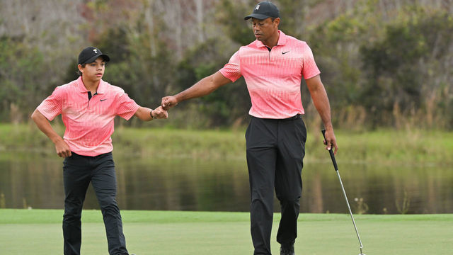 ORLANDO, FLORIDA - DECEMBER 17: Tiger Woods and his son, Charlie Woods, fist bump on the 14th green during the first round of the PGA TOUR Champions PNC Championship at The Ritz-Carlton Golf Club on December 17, 2022 in Orlando, Florida.