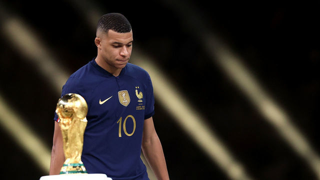 LUSAIL CITY, QATAR - DECEMBER 18: Kylian Mbappe of France looks dejected as they walk past the FIFA World Cup Qatar 2022 Winner's Trophy after presented the adidas Golden Boot award at the award ceremony following the FIFA World Cup Qatar 2022 Final match between Argentina and France at Lusail Stadium on December 18, 2022 in Lusail City, Qatar.