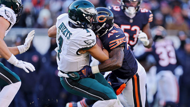 CHICAGO, ILLINOIS - DECEMBER 18: Jalen Hurts #1 of the Philadelphia Eagles is tackled by Joe Thomas #45 of the Chicago Bears during the second half at Soldier Field on December 18, 2022 in Chicago, Illinois.
