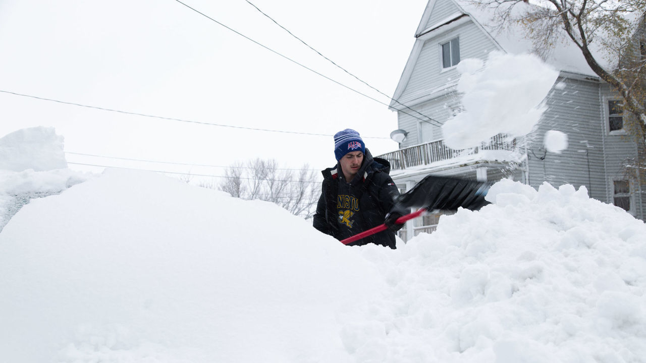 BUFFALO, NY - NOVEMBER 18: Thomas Gilmore works to free his buried car after a snowstorm in Buffalo, New York on Friday Nov. 18, 2022.
