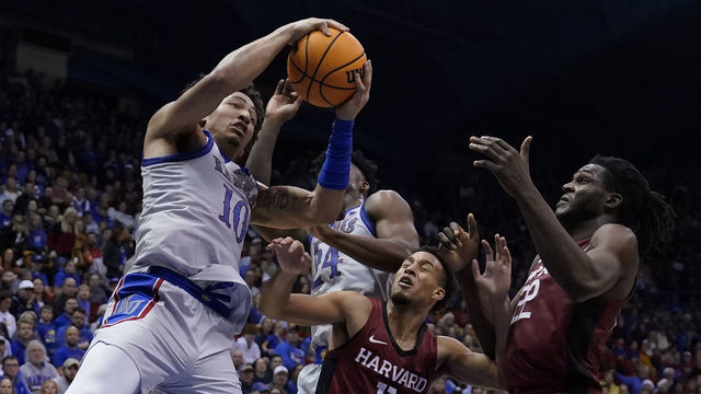 LAWRENCE, KANSAS - DECEMBER 22: Jalen Wilson #10 of the Kansas Jayhawks rebounds the ball against teammate K.J. Adams Jr. #24, Evan Nelson #11 and Justice Ajogbor #22 of the Harvard Crimson in the second half at Allen Fieldhouse on December 22, 2022 in Lawrence, Kansas.