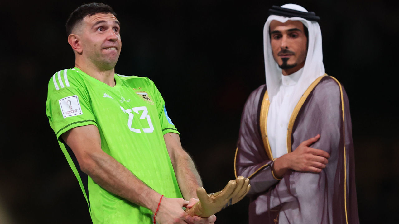 LUSAIL CITY, QATAR - DECEMBER 18: H.E Sheikh Jassim Bin Hamad Al Thani looks on as Emiliano Martinez of Argentina gestures with the world cup trophy during the FIFA World Cup Qatar 2022 Final match between Argentina and France at Lusail Stadium on December 18, 2022 in Lusail City, Qatar.