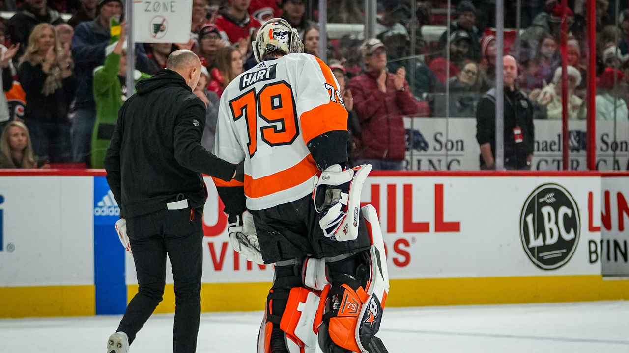 RALEIGH, NORTH CAROLINA - DECEMBER 23: Carter Hart #79 of the Philadelphia Flyers is helped off the ice after suffering an injury during the second period of a game against the Carolina Hurricanes at PNC Arena on December 23, 2022 in Raleigh, North Carolina.