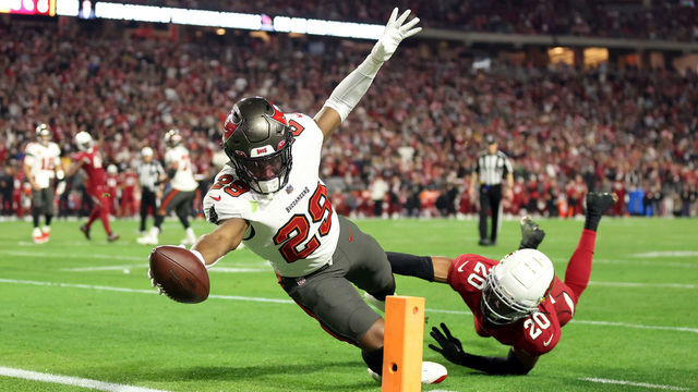 GLENDALE, ARIZONA - DECEMBER 25: Rachaad White #29 of the Tampa Bay Buccaneers stretches across the goal line for a touchdown as Marco Wilson #20 of the Arizona Cardinals defends during the 4th quarter of the game at State Farm Stadium on December 25, 2022 in Glendale, Arizona.