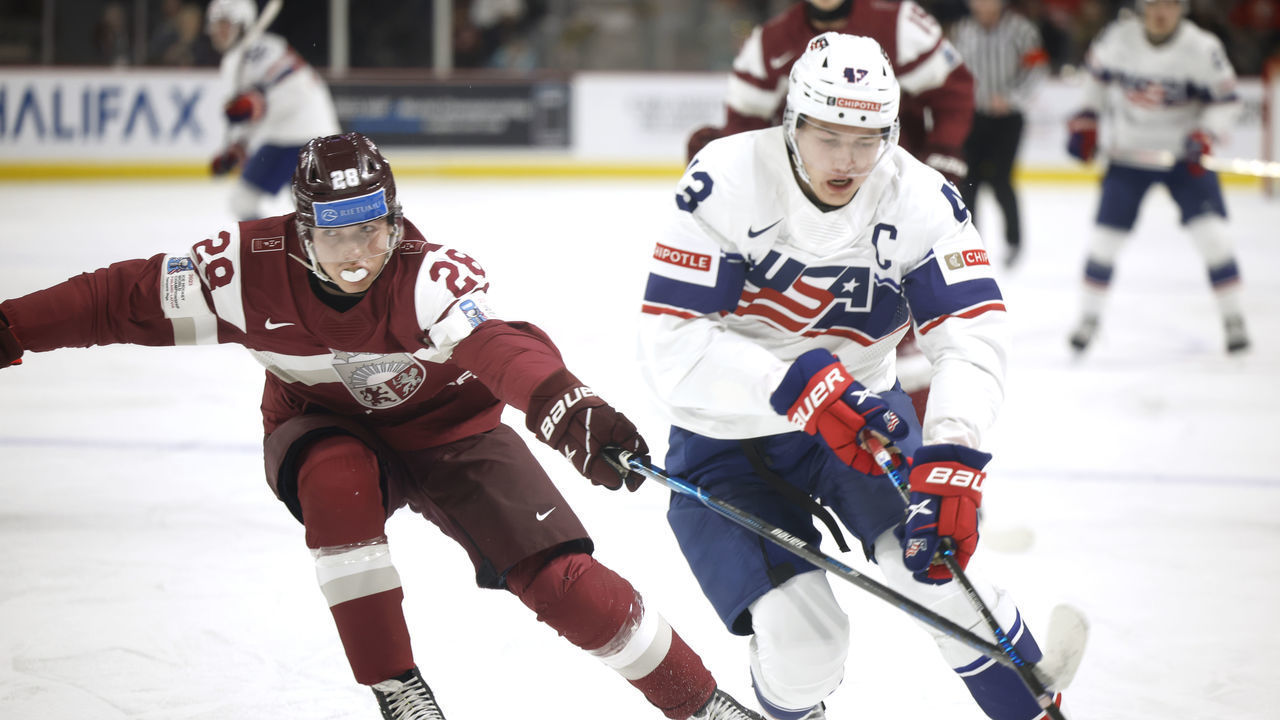 MONCTON, NB - DECEMBER 26: Luke Hughes #43 for team USA steps around Edgards Kazaks #28 for team Latvia during first period at Avenir Centre on December 26, 2022 in Moncton, Canada.