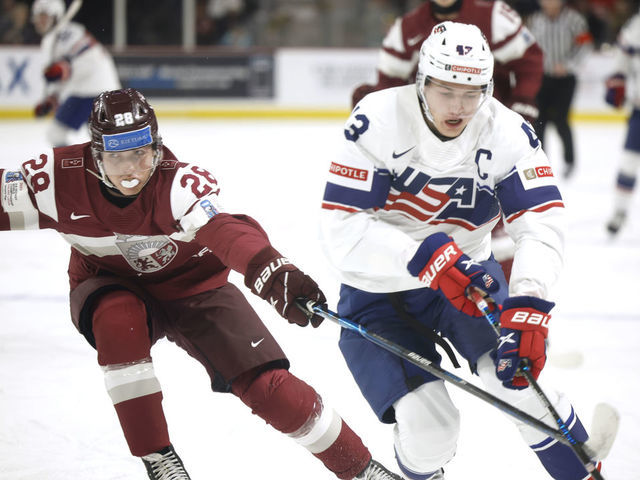 MONCTON, NB - DECEMBER 26: Luke Hughes #43 for team USA steps around Edgards Kazaks #28 for team Latvia during first period at Avenir Centre on December 26, 2022 in Moncton, Canada.