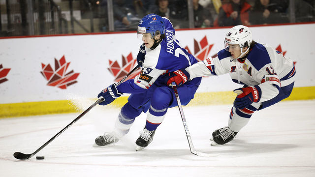 MONCTON, NB - DECEMBER 28: Samuel Honzek #19 of Team Slovakia skates around Sean Behrens #12 of Team USA during the first period of their game during the 2023 IIHF World Junior Championship at Avenir Centre on December 28, 2022 in Moncton, Canada.