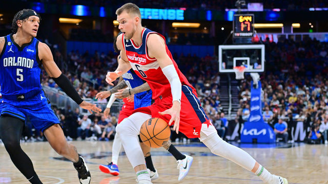 ORLANDO, FLORIDA - DECEMBER 30: Kristaps Porzingis #6 of the Washington Wizards drives to the basket against Paolo Banchero #5 of the Orlando Magic in the second half of a game at Amway Center on December 30, 2022 in Orlando, Florida.
