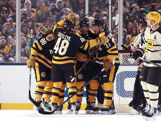 BOSTON, MASSACHUSETTS - JANUARY 02: Jake DeBrusk #74 of the Boston Bruins celebrates with teammates after scoring a goal against the Pittsburgh Penguins during the third period in the 2023 Discover NHL Winter Classic at Fenway Park on January 02, 2023 in Boston, Massachusetts.